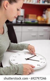 A Woman Changes The Time On A Clock, Daylight Savings Or Change Return To Standard Time