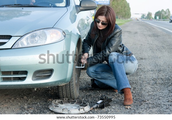 woman changing the broken\
Tire