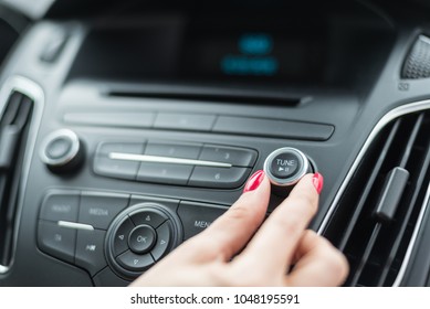 Woman Changing Frequency On Car Radio. Modern Car Interior