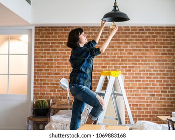 Woman Changing Lightbulb