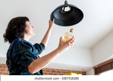 Woman Changing Lightbulb