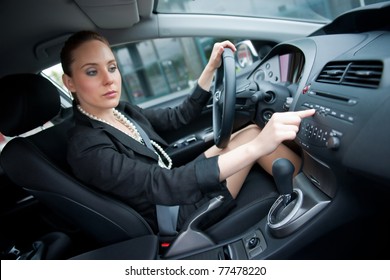 Woman Changing Radio Station While Driving Car