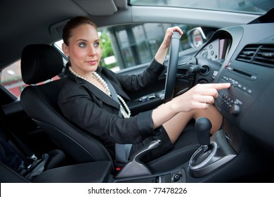 Woman Changing Radio Station While Driving Car