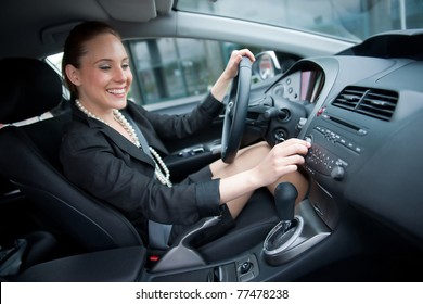 Woman Changing Radio Station While Driving Car