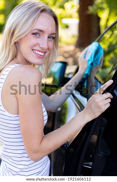 woman is changing\
windscreen wipers on a\
car