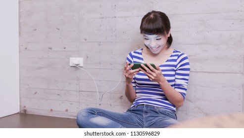 Woman With Charging Battery On Mobile Phone At Home