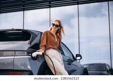 Woman charging electric car at the charging station - Powered by Shutterstock