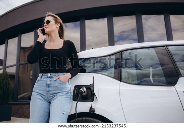Woman
charging electro car at the electric gas
station