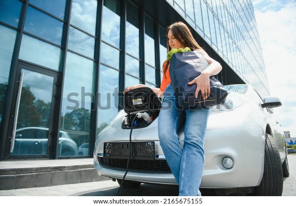 Woman
charging electro car at the electric gas
station.