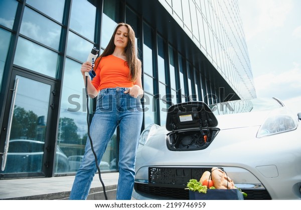 Woman\
charging electro car at the electric gas\
station.