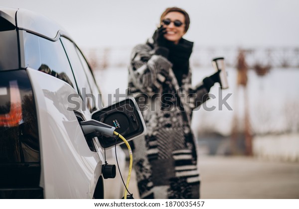 Woman charging electro\
car at the street