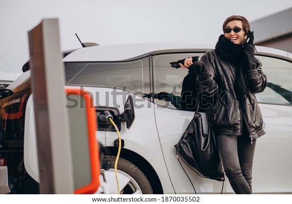 Woman charging electro
car at the street