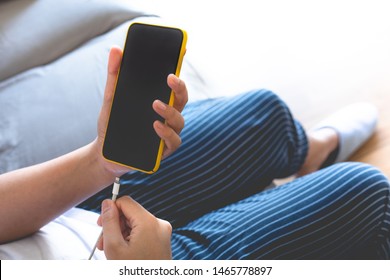 Woman charging smartphone.energy bank.low battery.electronic equipment concepts - Shutterstock ID 1465778897