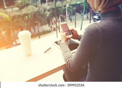 女性は携帯電話でおしゃべりをしているが、カフェではデジタルタブレット、クレジットカード、コーヒーを持ち帰る。女性は携帯電話で夕食の予約レストランに行っている