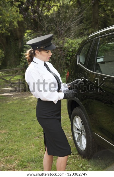 Woman\
chauffeur using a key flob to open the car\
door