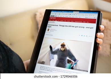 Woman Checking BBC News Headlines On Coronavirus In The US On Tablet. COVID-19 Theme