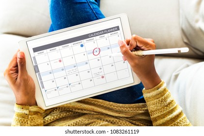 Woman checking calendar on digital tablet