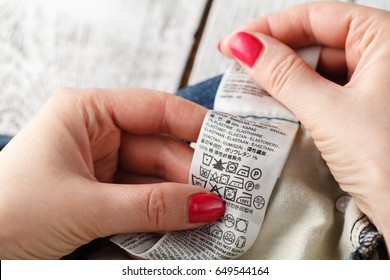 Woman Checking The Care Label Of A Pair Of Jeans