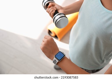 Woman Checking Fitness Tracker In Gym, Closeup