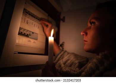 Woman Checking Fuse Box At Home During Power Outage Or Blackout. No Electricity Concept