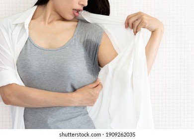 The woman is checking her armpit sweat. - Shutterstock ID 1909262035