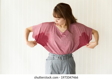 The woman is checking her armpit sweat. - Shutterstock ID 1973347466