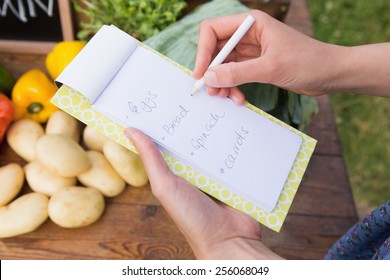 Woman checking her shopping list on a sunny day