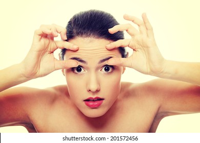 Woman Checking Her Wrinkles On Her Forehead.