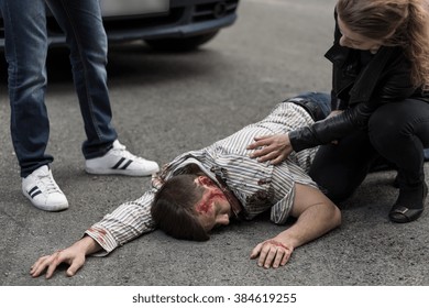 Woman Checking If Man Hit By A Car Is Alive