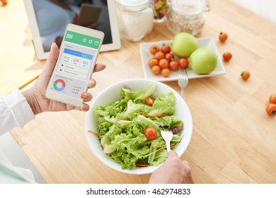 Woman Checking Nutrition Information And Calories On Her Phone When Eating