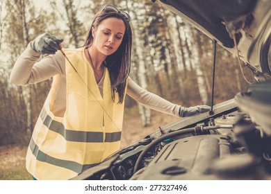 Woman Checking Oil Level On  A Roadside