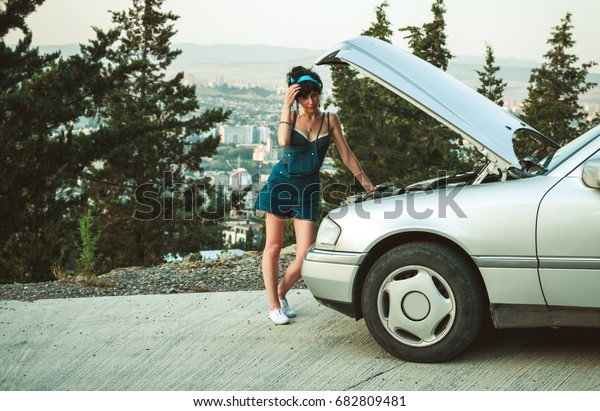 Woman checking the\
problems with the car