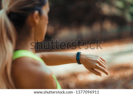 Woman Checking Progress on Smart Watch after Outdoor Training