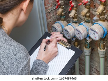 Woman checking the readout on a water meter. Household water consumption, cost of water concept image.