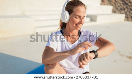 Woman checking smartwatch while exercising outdoors