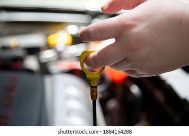 Woman Checking The Transmission Fluid In An Automobile