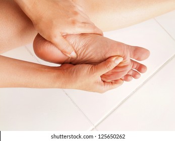 Woman Checks Her Aching Foot