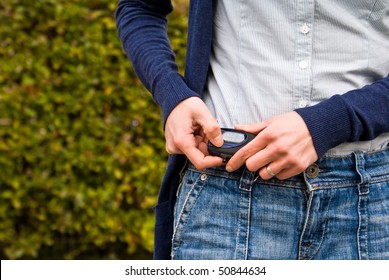 A Woman Checks Her Pedometer While Walking Outdoors