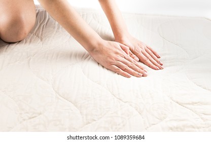 The woman checks how soft the new mattress is - Shutterstock ID 1089359684