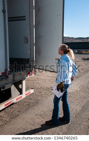 A woman checks to see how the load is stacked and where it is placed in the trailer before closing the door and placing the seal.