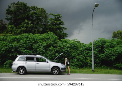 A Woman Checks Under The Hood Of Her Car