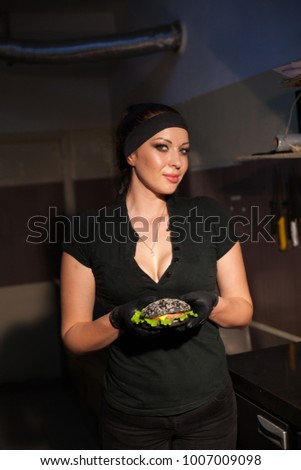 woman chef in the kitchen preparing a hamburger sandwich