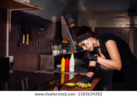 woman chef in the kitchen preparing a hamburger sandwich