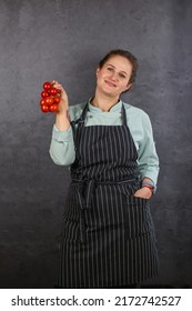 Woman Chef On A Dark Background. Mint Coat And Black Apron. Rhubarb