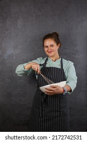 Woman Chef On A Dark Background. Mint Coat And Black Apron. Rhubarb