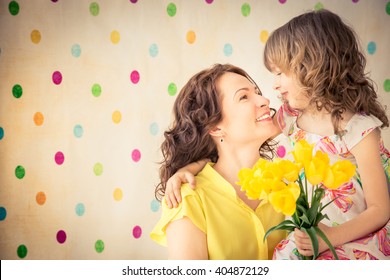 Woman And Child With Bouquet Of Flowers At Home. Spring Family Holiday Concept. Mother's Day