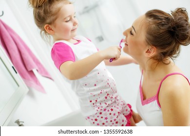 Woman and child brush their teeth - Shutterstock ID 1355592638