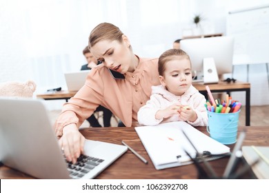 The woman with the child came to work. She works with her daughter in her arms. This is a business office.