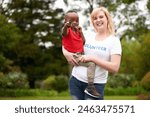 Woman, child and portrait for volunteering at charity for kids and community service in park. Diversity, orphan and female person with kindness for help, missionary work and care in adoption shelter