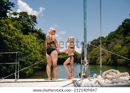 a woman and a child relax on a yacht in the Indian ocean near the island of Mauritius. Coral reef with turquoise water next to a tropical island
